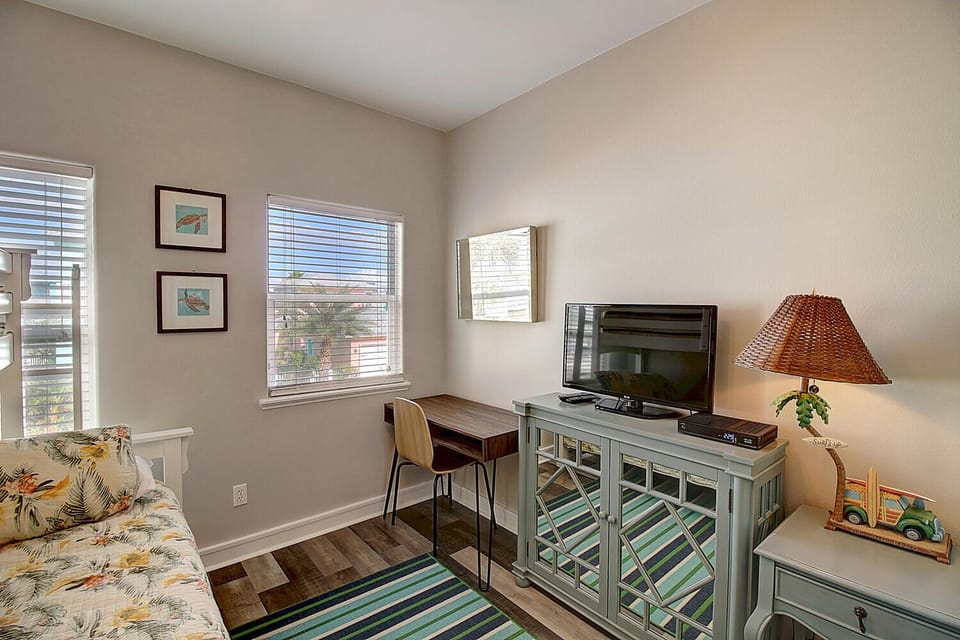 Settle into your bright workspace corner with tropical-print seating, dedicated desk area, and entertainment center for productive days and relaxing evenings.