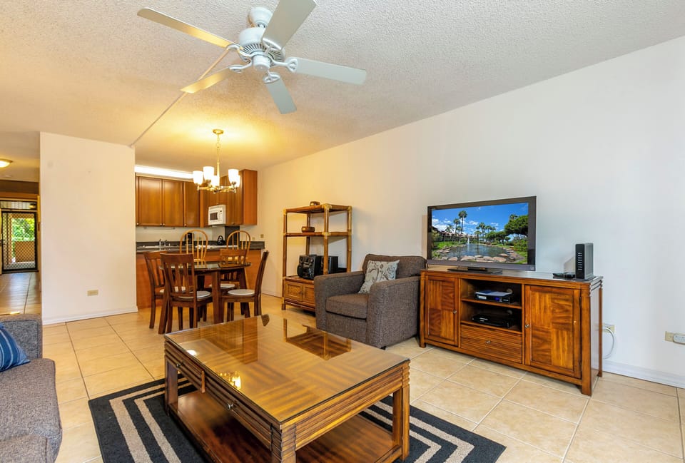 Picture yourself unwinding in this inviting living space, where warm wood tones and comfortable seating await. The open layout flows effortlessly from relaxing to dining, perfect for your stay.