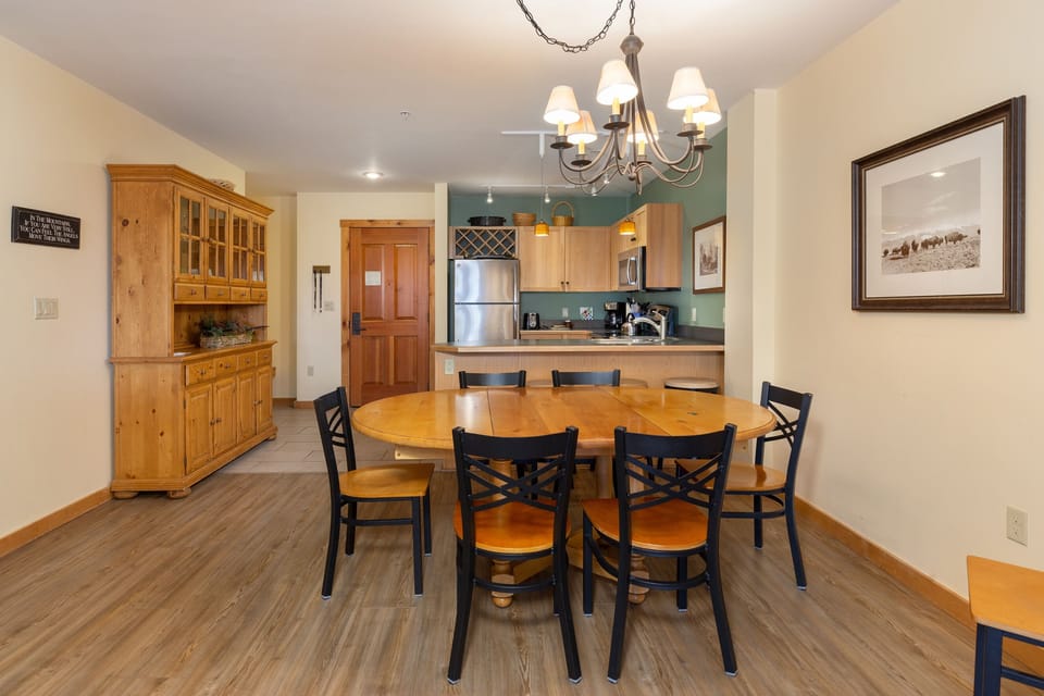 Gather around your spacious dining table for memorable meals, with a fully equipped kitchen and elegant chandelier creating the perfect atmosphere for your stay.