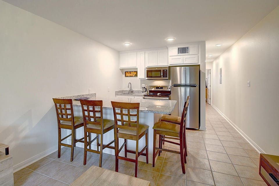 Your modern kitchen features granite countertops, stainless steel appliances, and a breakfast bar perfect for morning coffee or casual meals together.