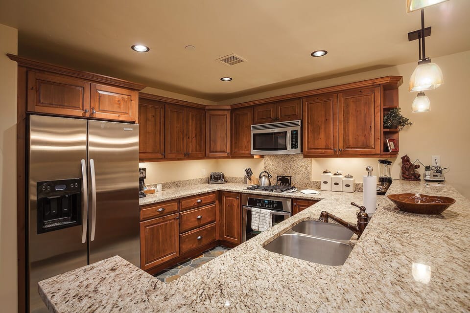 Your fully equipped gourmet kitchen features granite counters, stainless appliances, and rich wood cabinetry for effortless meal preparation.