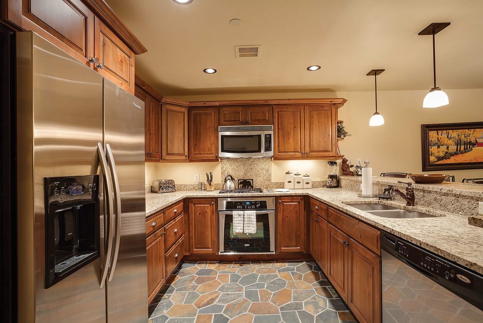 Cook your favorite meals in this fully equipped kitchen with granite counters, stainless appliances, and warm wood cabinetry.
