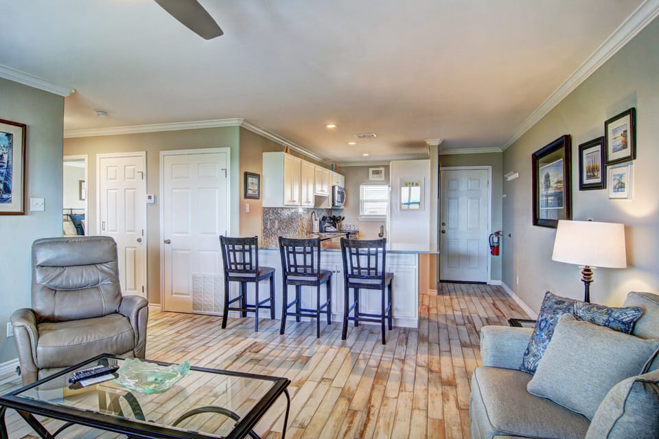 Relax in your open-concept living space with gleaming hardwood floors, comfortable seating, and a kitchen bar perfect for morning coffee.