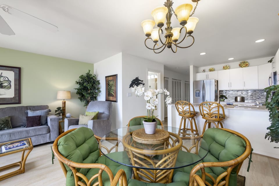 Unwind in your bright, open living and dining space with cozy seating, tropical touches, and a fully equipped kitchen ready for your stay.