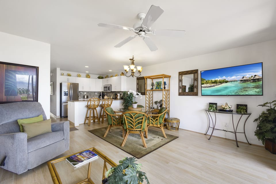 Relax in your open-concept living and dining area, beautifully designed with natural light, tropical accents, and a ceiling fan keeping things cool and comfortable.