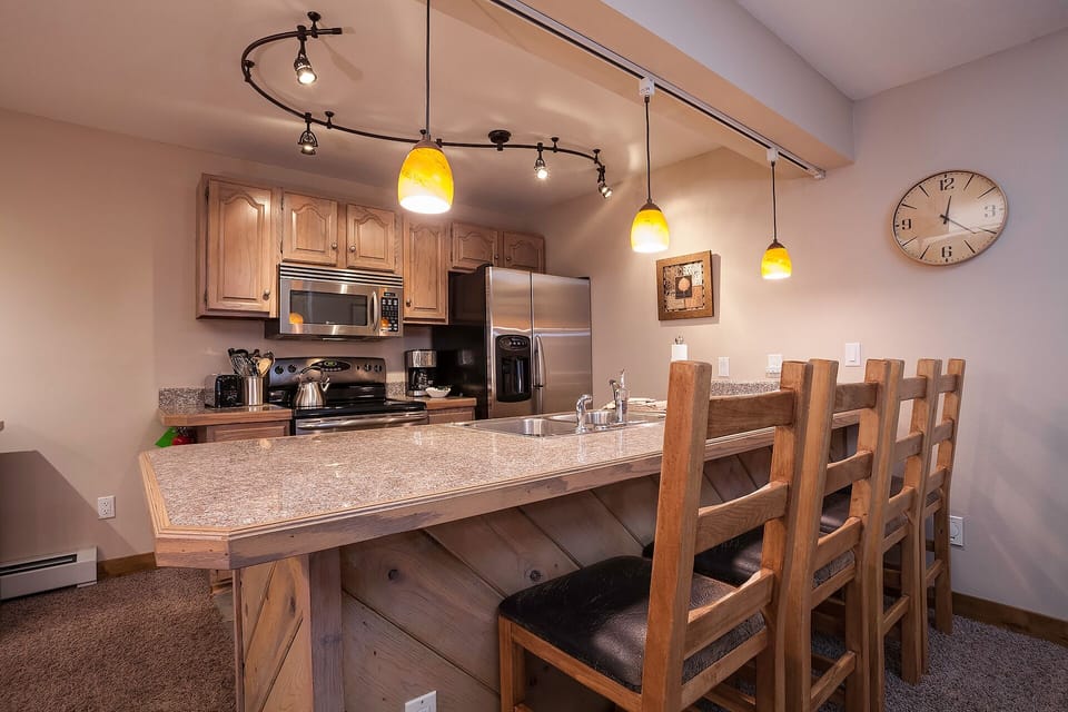 Gather around your spacious kitchen island where granite countertops and warm pendant lighting create the perfect spot for shared meals and conversations.
