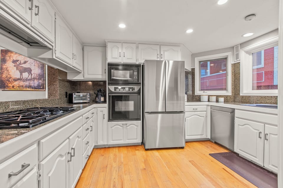 Your gourmet kitchen features granite counters, stainless appliances, and warm wood floors.