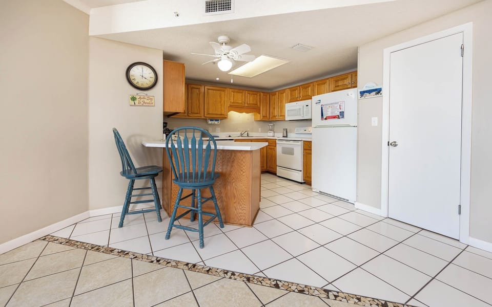 Gather around the breakfast bar, perfect for coffee or casual meals in this inviting kitchen space