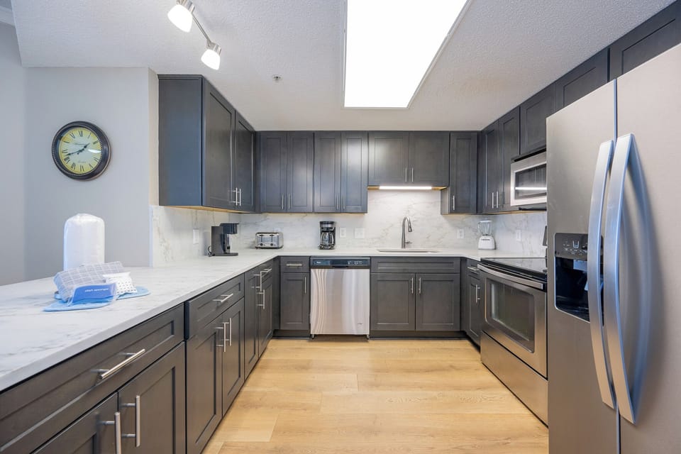 Dark cabinetry and marbled counters invite you to prepare a fresh meal with ease in the kitchen