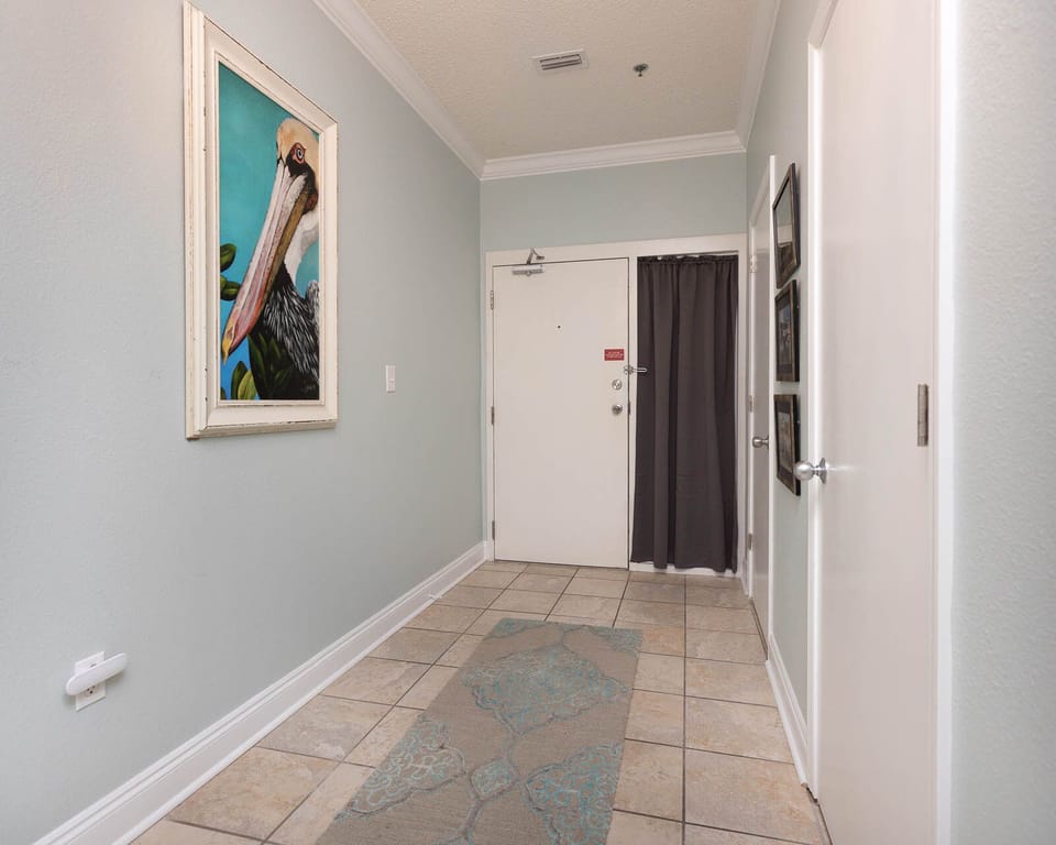 Brightly painted walls and a decorative pelican artwork welcome guests in this inviting entryway with tiled flooring