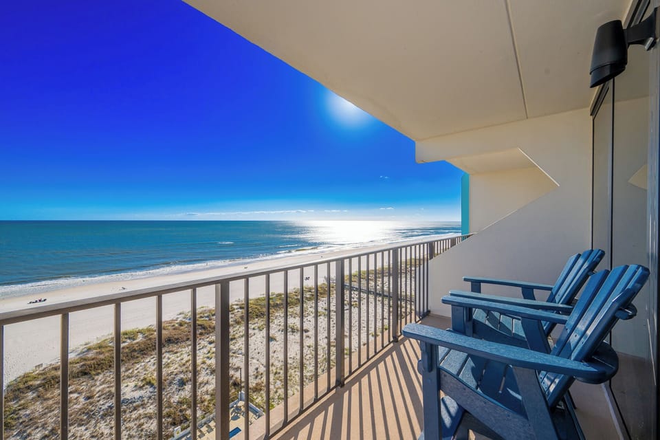 Enjoy stunning beachfront views from this inviting balcony with comfortable seating for relaxation and unwinding