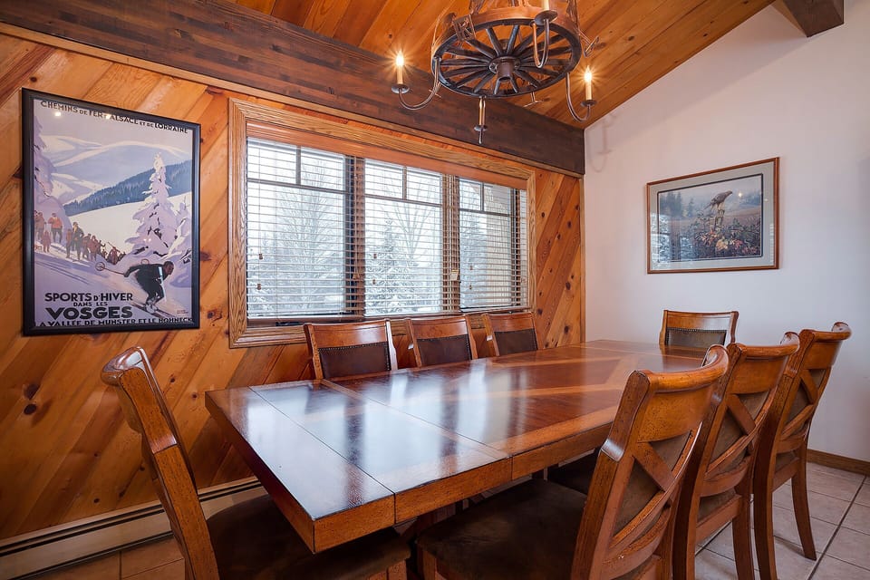 Your rustic dining room features a handcrafted wooden table beneath exposed beams, perfect for sharing memorable meals with family and friends.