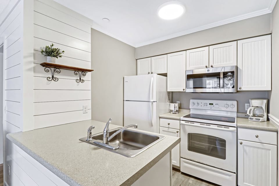 Kitchen - Love the shiplap accent wall in this bright and newly painted fully equipped kitchen.