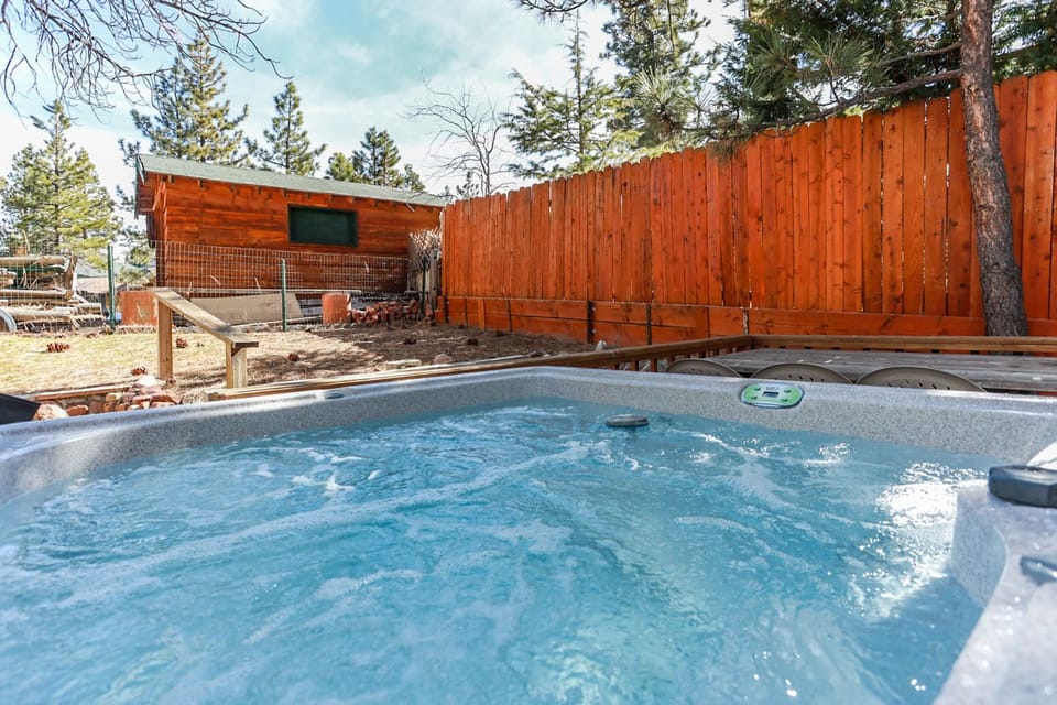 Private outdoor hot tub, surrounded by tall pines, perfect for relaxing under the trees after a day of adventure—enjoy peaceful forest views, fresh air, and a truly rejuvenating stay.