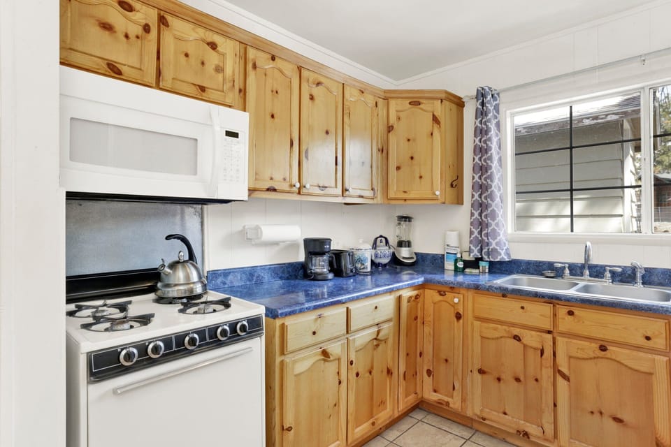 Fully equipped cabin kitchen with ample cabinetry, stove, fridge, microwave, and coffee maker—perfect for cooking meals, morning coffee, and feeling right at home on your stay.