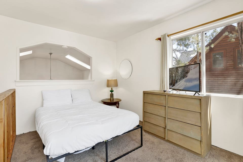 Peaceful cabin bedroom with plush bedding, and beautiful views—ideal for restful nights, cozy mornings, and a relaxing mountain escape.