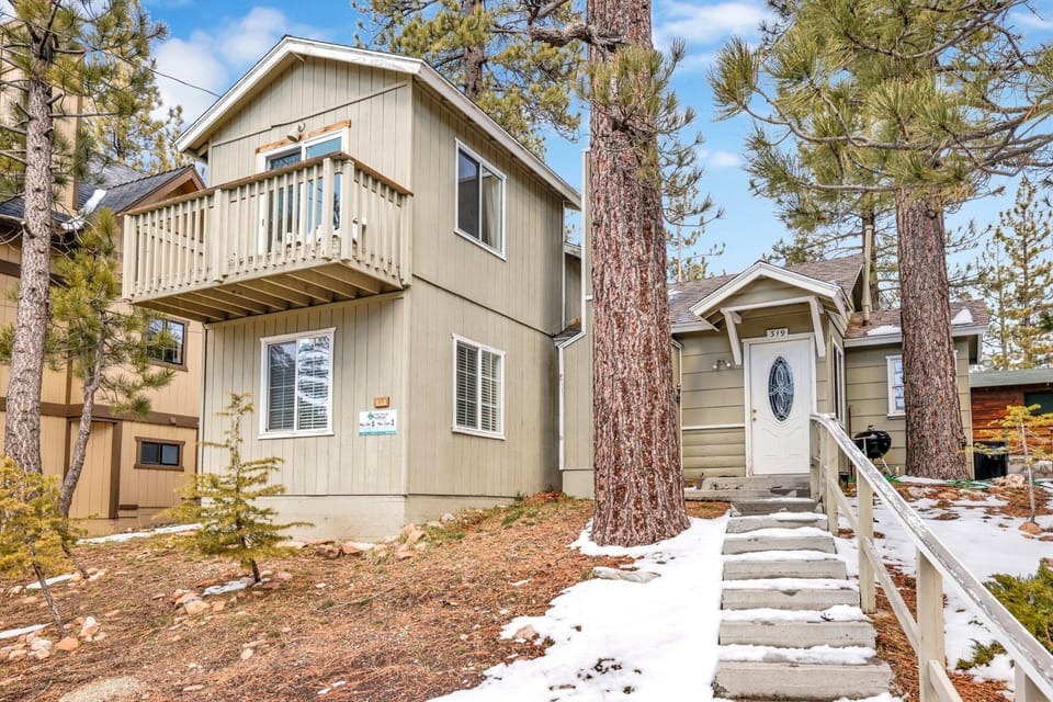 Welcoming cabin entry surrounded by towering pine trees, offering fresh mountain air and a peaceful forest setting—the perfect first impression for your Big Bear Lake getaway.