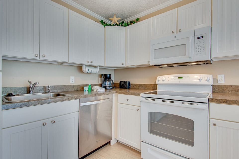 Ocean Dunes 401 - Kitchen - Completely furnished kitchen that looks to dining area and ocean view from balcony