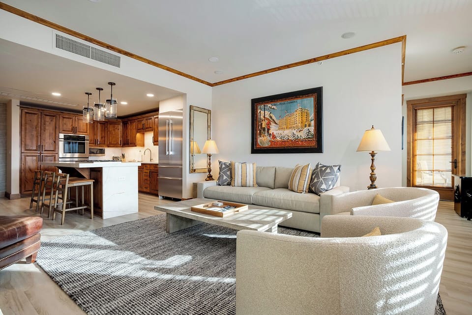 Relax in your spacious, open living area with plush seating and a fully equipped kitchen at your fingertips. Natural light, refined wood accents, and stylish decor create a welcoming mountain retreat where you can truly unwind.