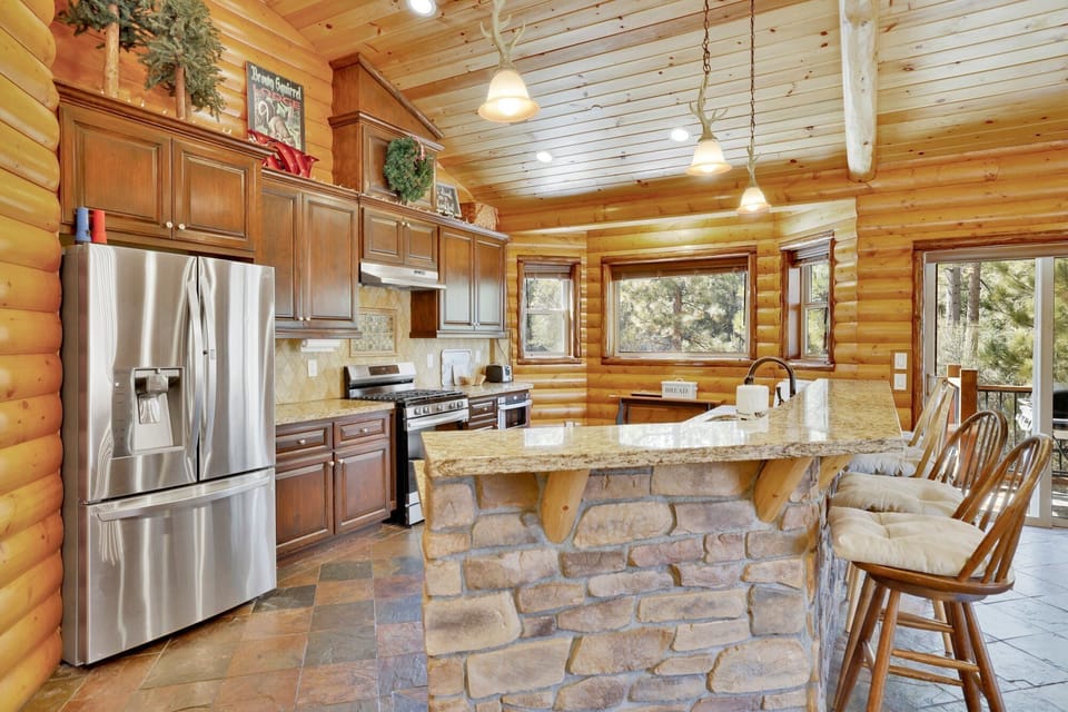 Fully equipped cabin kitchen with ample cabinetry, stove, fridge, microwave, and coffee maker—perfect for cooking meals, morning coffee, and feeling right at home on your stay.