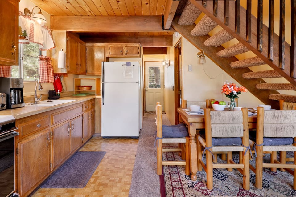 Fully equipped cabin kitchen with ample cabinetry, stove, fridge, microwave, and coffee maker—perfect for cooking meals, morning coffee, and feeling right at home on your stay.