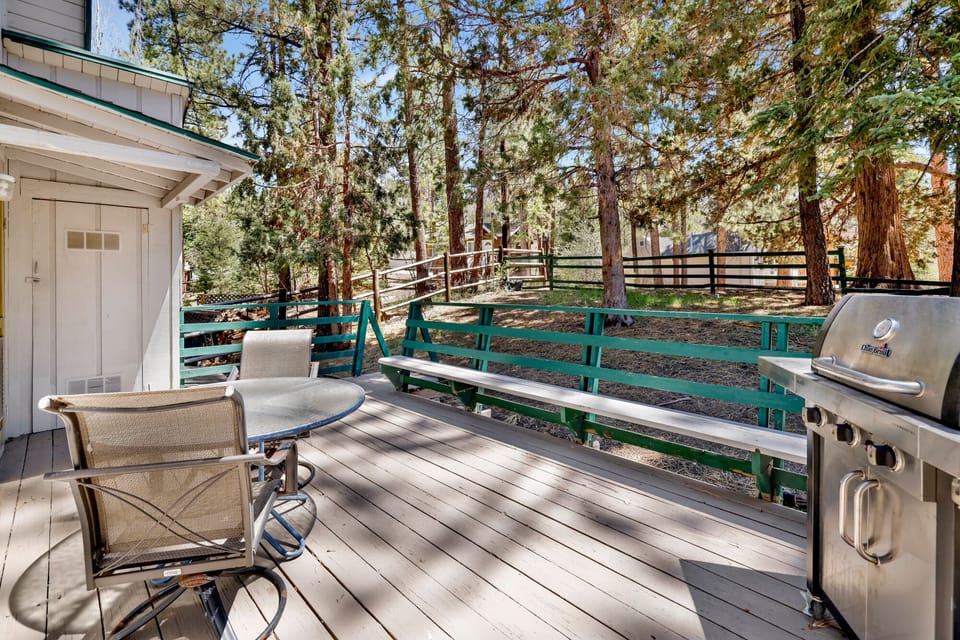 Private outdoor deck with a BBQ, surrounded by tall pines, perfect for relaxing under the trees after a day of adventure—enjoy peaceful forest views, fresh air, and a truly rejuvenating stay.