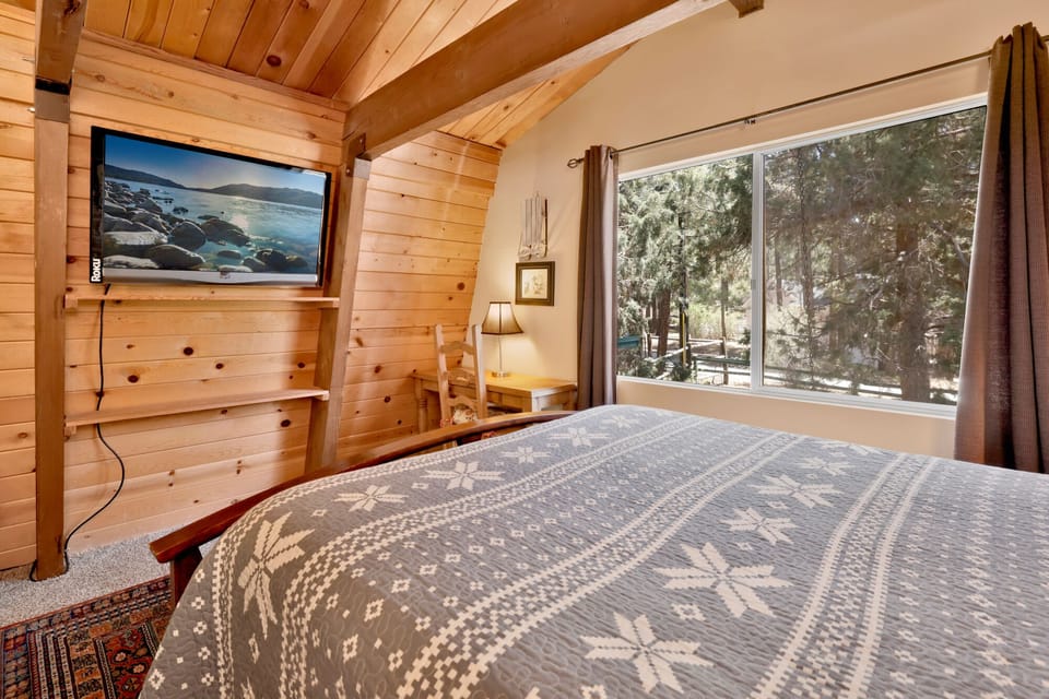 Peaceful cabin bedroom with plush bedding, and beautiful views—ideal for restful nights, cozy mornings, and a relaxing mountain escape.