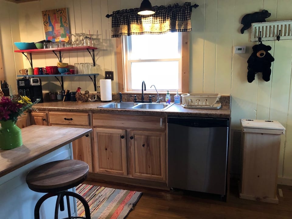 The kitchen has a dishwasher and coffee pot that has a carafe and k-cup combined