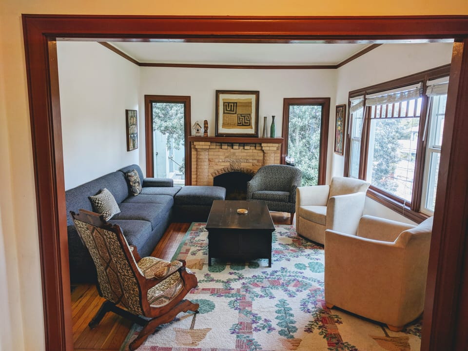 Living room w/ great light, art & big TV (not in pic). Opening is to the kitchen