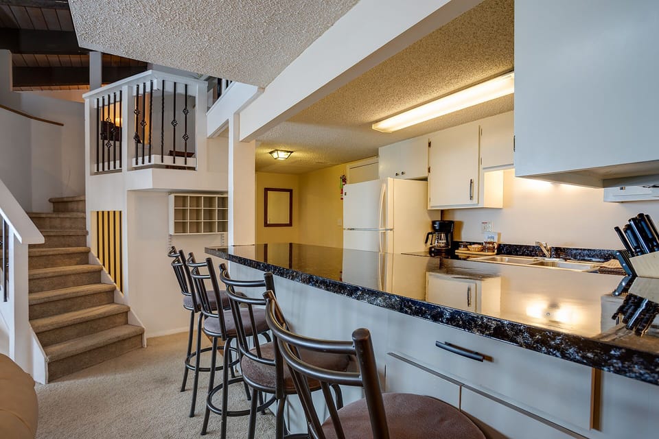 Your spacious kitchen features granite countertops, breakfast bar seating, and everything you need to prepare meals during your stay.