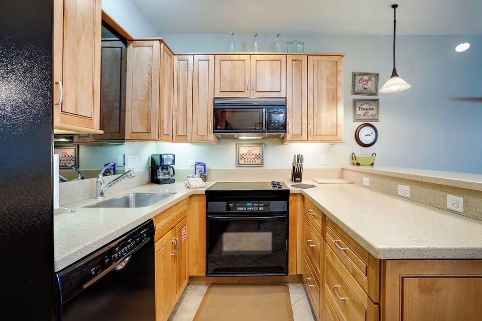 Your fully equipped kitchen awaits with warm wood cabinets, granite counters, and modern appliances for creating memorable meals together.