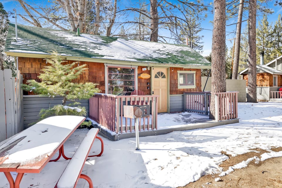 Enjoy outdoor dining on a private cabin deck with picnic table, surrounded by trees and fresh mountain air—perfect for morning coffee, and relaxing nature-filled getaways.