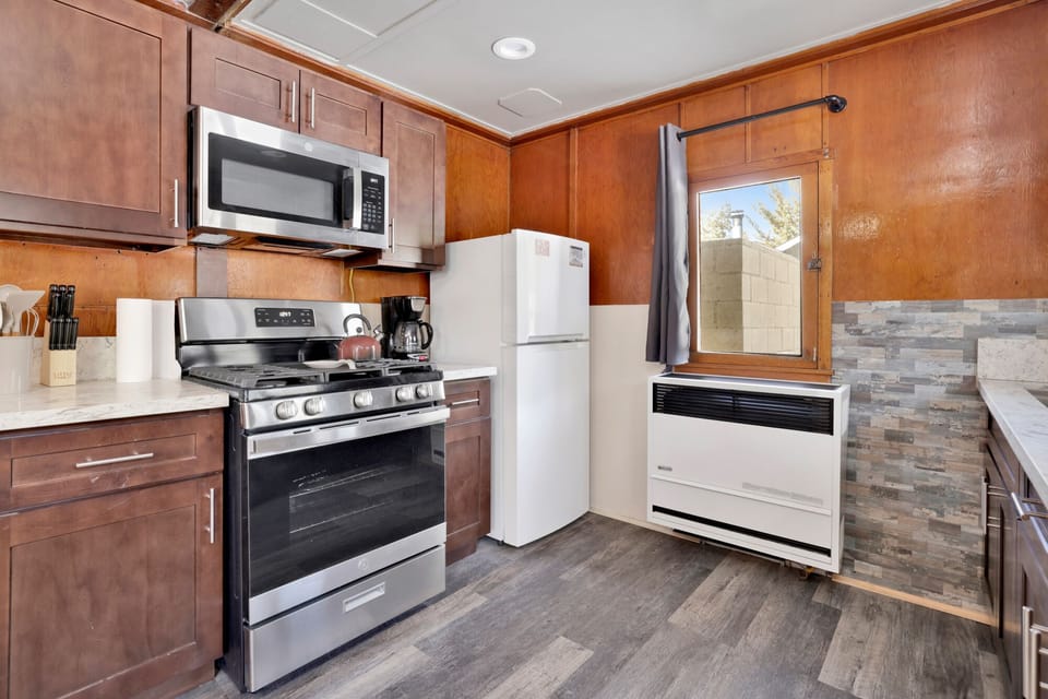 Kitchen with a refrigerator, stove, oven, microwave, and a coffee machine.