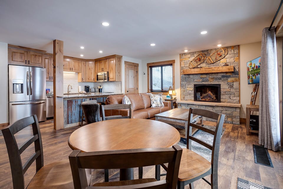 Cozy up in your alpine retreat with rustic wood finishes, a crackling stone fireplace, and modern kitchen—perfect for mountain getaways.