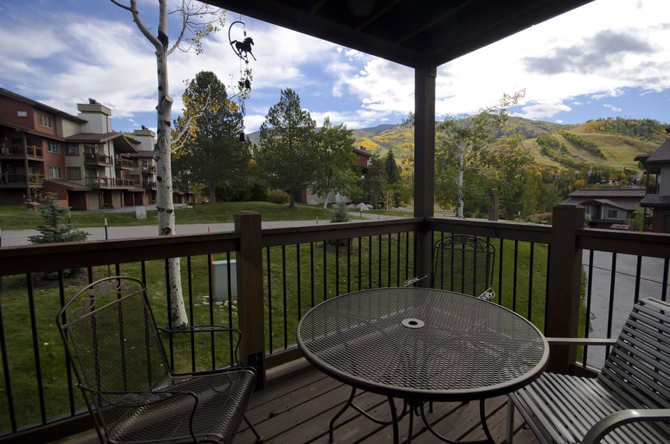 Enjoy your morning coffee at this cozy table with stunning mountain views stretching across golden autumn hills.