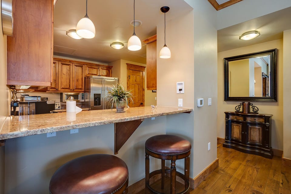 Your gourmet kitchen features granite counters, bar seating, and warm pendant lighting for memorable meals together.