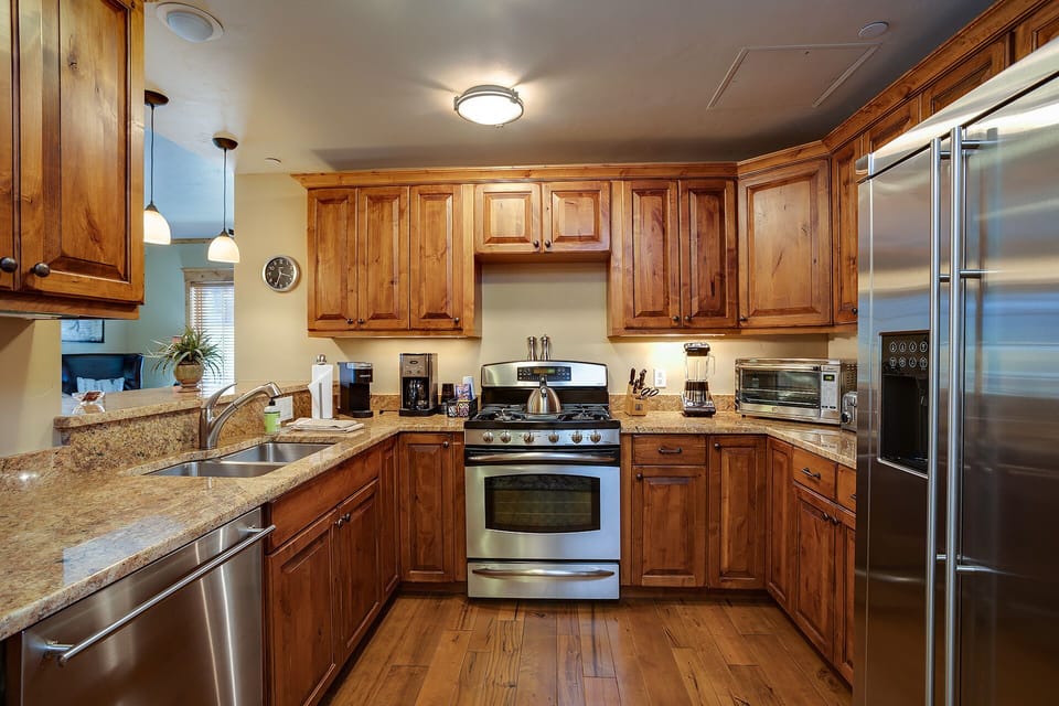 Step into your gourmet kitchen featuring rich wood cabinetry, granite countertops, and top-tier stainless steel appliances perfect for creating memorable meals.