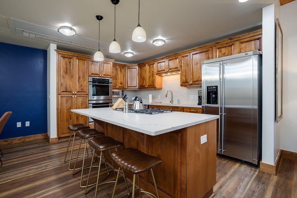 Your gourmet kitchen features warm wood cabinetry, marble countertops, and premium stainless steel appliances for memorable meal prep.