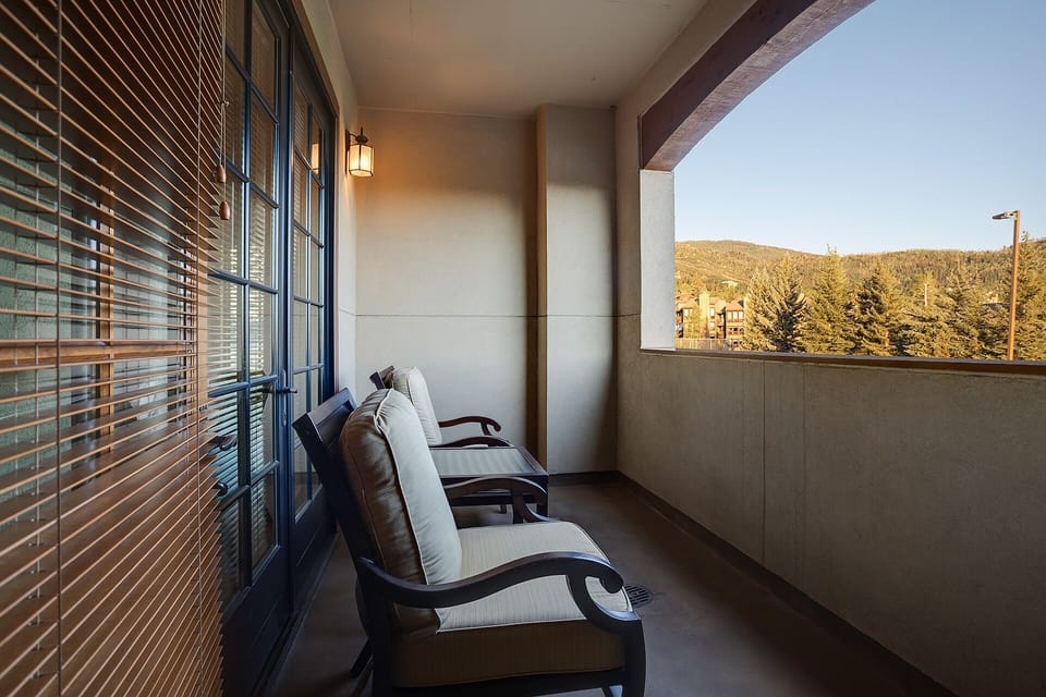 Unwind on your private balcony with mountain views, where comfortable seating and warm lighting create the perfect evening retreat.