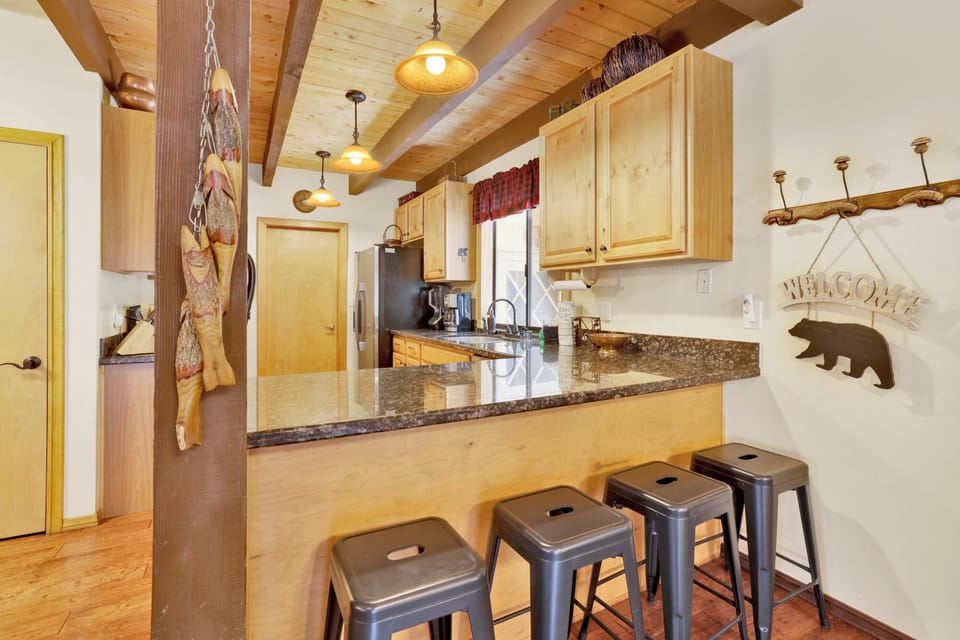 Fully equipped cabin kitchen with wood cabinets, stove, fridge, microwave, and coffee maker—perfect for cooking meals, morning coffee, and feeling right at home on your stay.