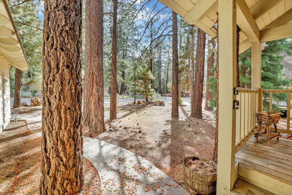 Welcoming cabin entry surrounded by towering pine trees, offering fresh mountain air and a peaceful forest setting—the perfect first impression for your Big Bear Lake getaway.