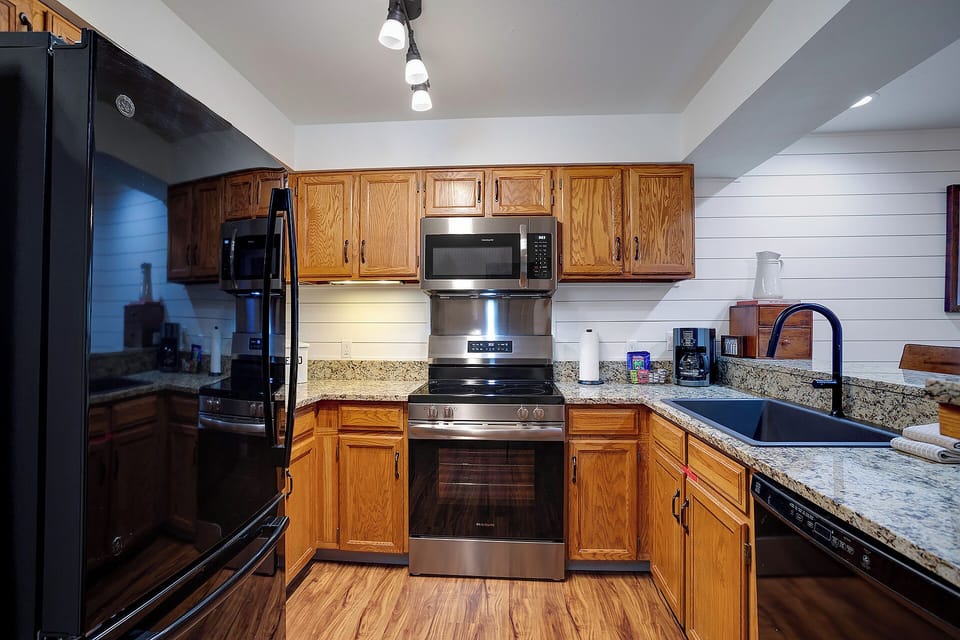 Your fully equipped kitchen awaits with granite countertops, stainless steel appliances, and warm wood cabinets—perfect for preparing your favorite meals.
