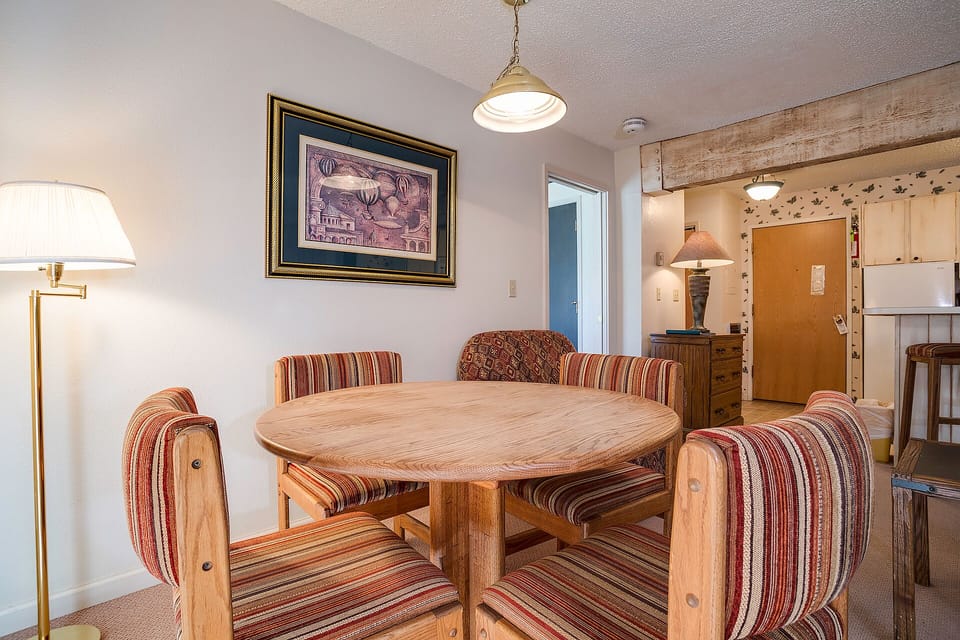 Gather around your charming dining table with warm striped seating, perfect for intimate meals together under soft pendant lighting.