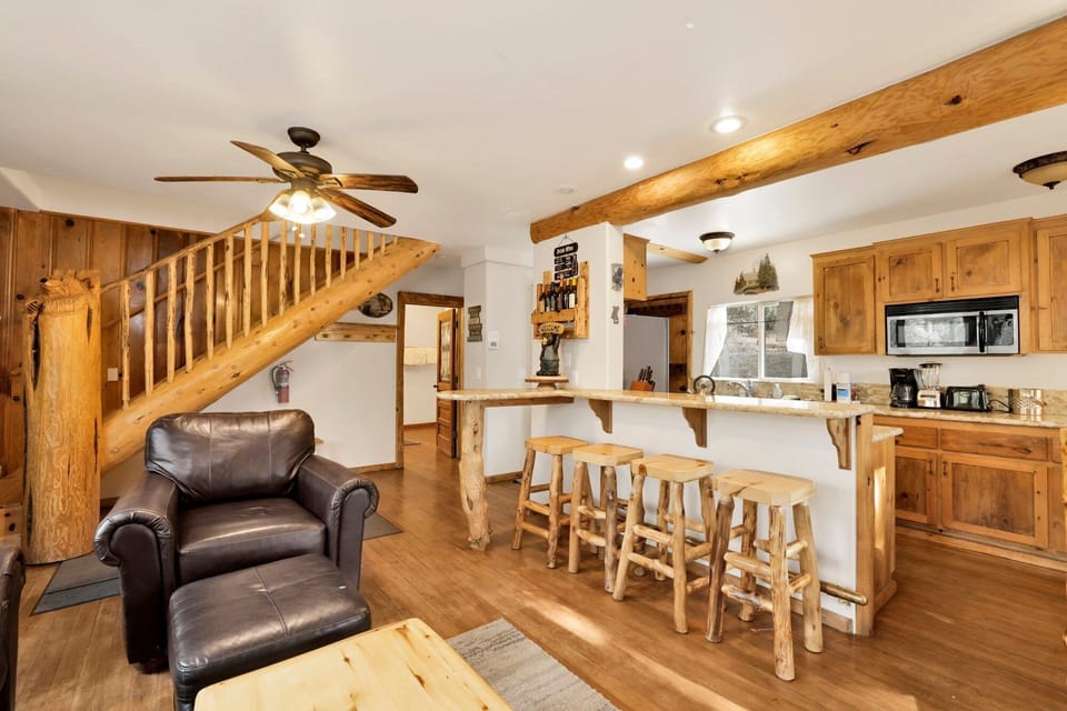 Relax in this warm, rustic living space featuring a leather armchair and a massive timber breakfast bar.