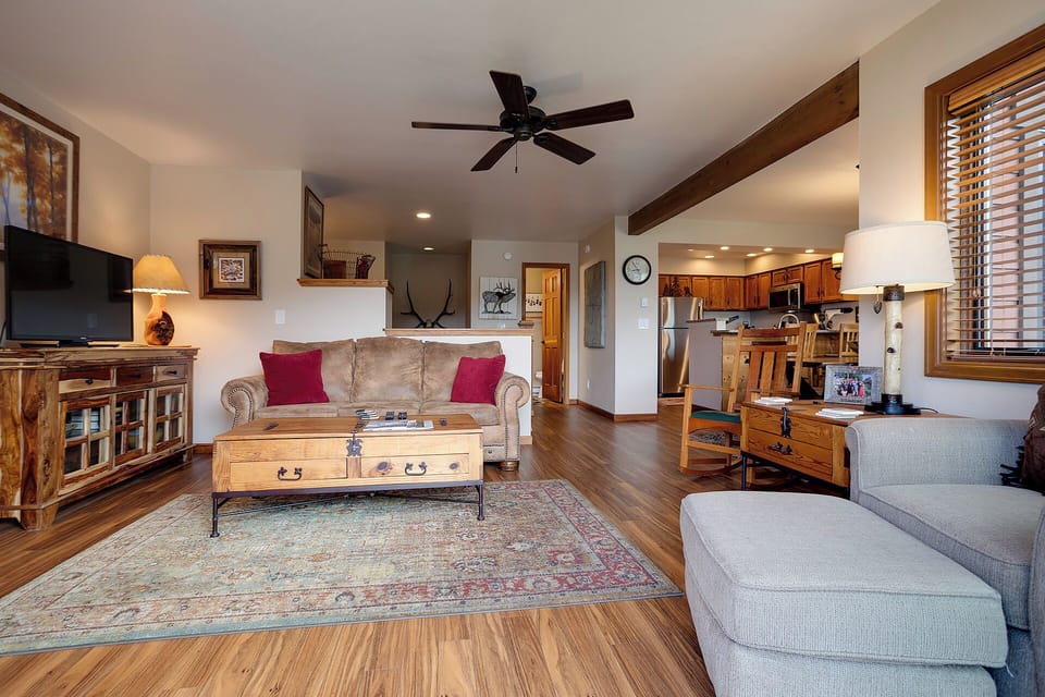 Relax in your open-concept living space where rustic charm meets modern comfort, featuring exposed beams and cozy seating for memorable evenings.