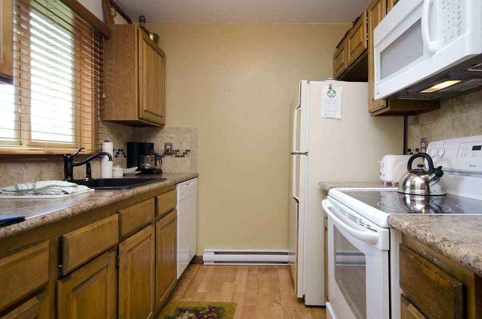 Your fully equipped kitchen invites culinary adventures with warm wood cabinets, granite counters, and all the essentials for home-cooked meals.