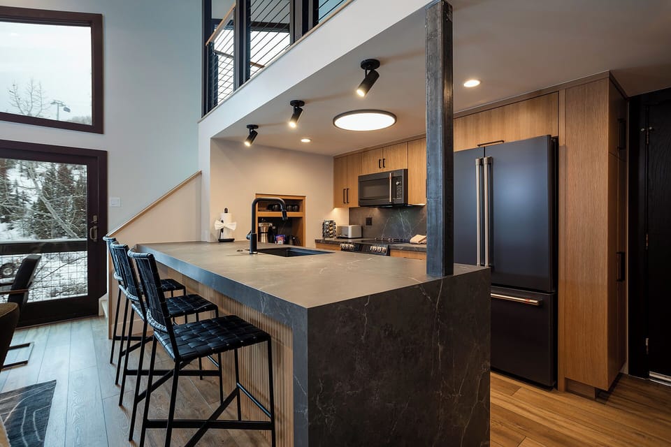 Your modern kitchen features sleek quartz counters, premium appliances, and stylish bar seating perfect for morning coffee or evening conversations.