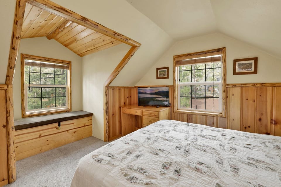 Peaceful cabin bedroom with plush bedding, and beautiful views—ideal for restful nights, cozy mornings, and a relaxing mountain escape.
