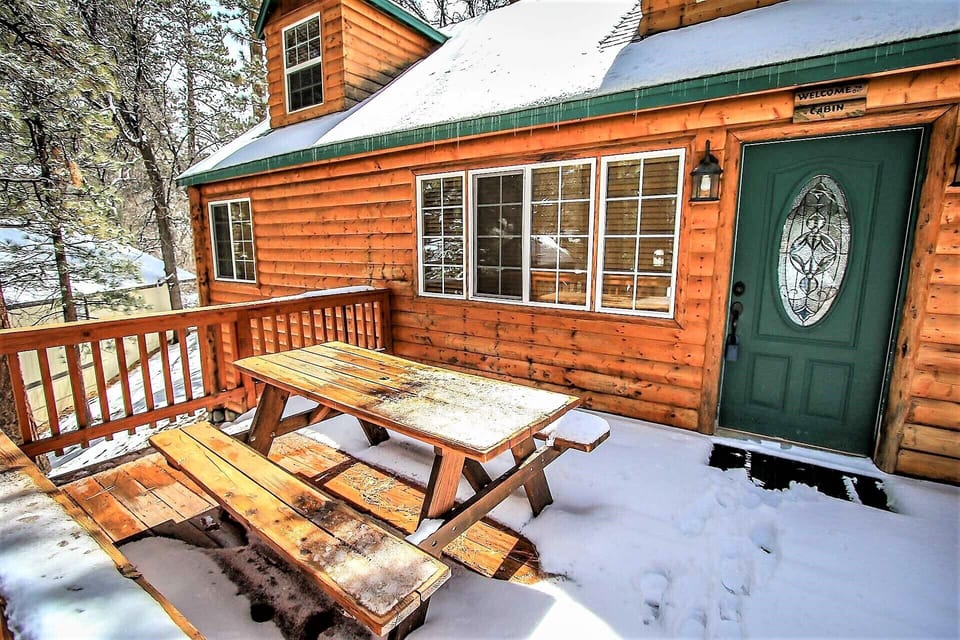 Welcoming cabin entry surrounded by towering pine trees, offering fresh mountain air and a peaceful forest setting—the perfect first impression for your Big Bear Lake getaway.