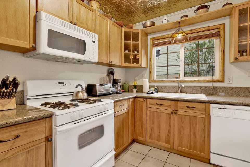 Fully equipped cabin kitchen with ample cabinetry, stove, fridge, and coffee maker—perfect for cooking meals, morning coffee, and feeling right at home on your stay.
